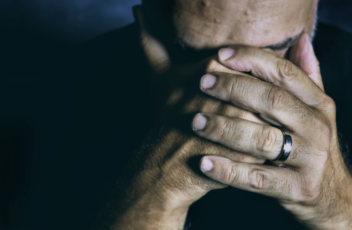 A Sad Man Covering his Face with his Hands